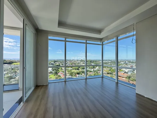 Sala ampla com vista panorâmica para a paisagem externa.