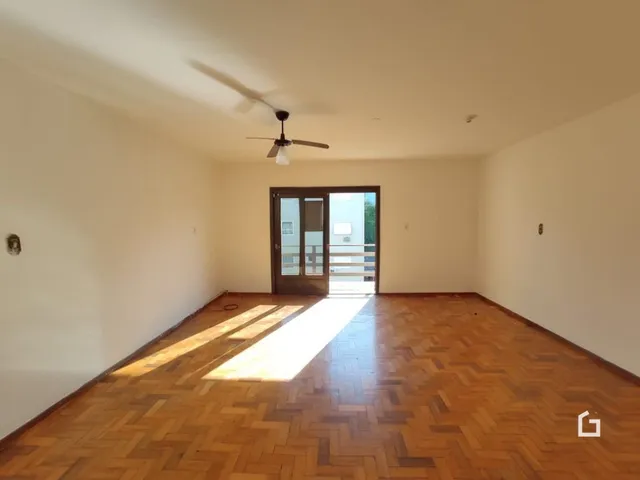 Sala de estar com piso de madeira clara e paredes brancas.