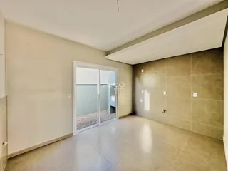 Interior de uma sala com piso de cerâmica e paredes claras.