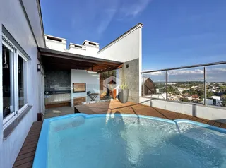 Fachada de uma residência com piscina e deck em Lajeado.