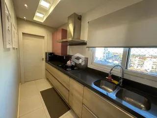 Vista da cozinha moderna com bancadas escuras e armários claros.