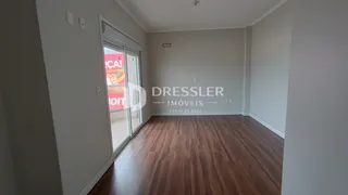 Vista interna de um ambiente com piso de madeira e portas de vidro.