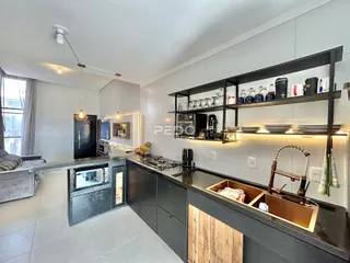 Ambiente de sala de estar e cozinha em um imóvel no Brasil.