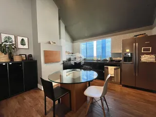 Foto de uma cozinha moderna com ilha de vidro e piso de madeira.
