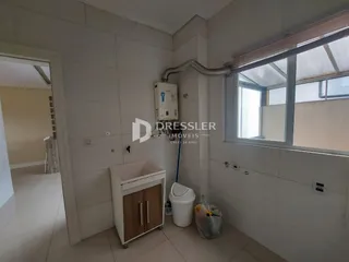 Interior de um banheiro com paredes brancas e piso de cerâmica.