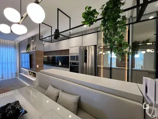 Sala de estar e cozinha moderna com grandes janelas e plantas.