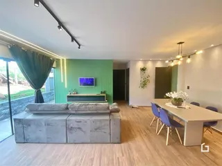 Sala de estar com sofá e área de jantar em um imóvel no Brasil.