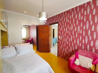 Quarto com parede decorada em vermelho e cabeceira de madeira
