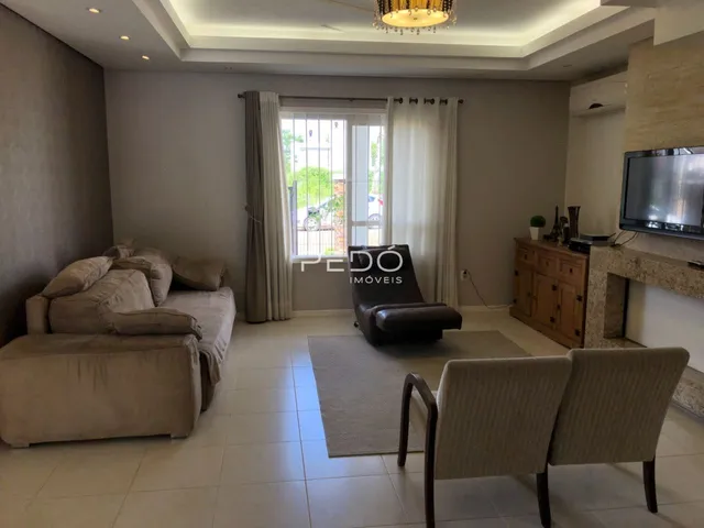 Sala de estar com sofá e poltronas em ambiente claro.