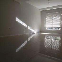 Ambiente interno com paredes brancas e piso reflexivo.