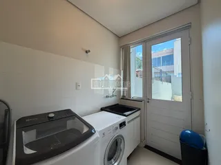 Foto de um interior mostrando máquinas de lavar e cozinha.