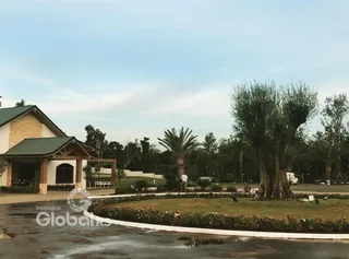 Vista externa de uma residência com paisagismo e árvores no entorno.