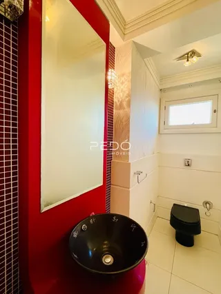 Foto de um banheiro com azulejos vermelhos e brancos.