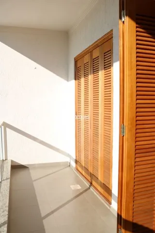 Um corredor interno com painéis de madeira é visível na propriedade.