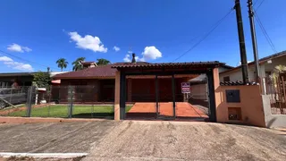 Fachada de uma residência com telhado de telha vermelha e cerca frontal.
