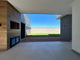 Vista externa de um terraço com piso de concreto e parede de madeira.