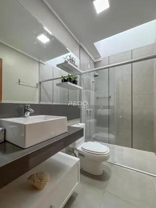 Foto de um banheiro moderno com box de vidro e piso claro.