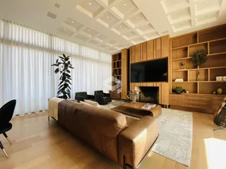 Sala de estar com decoração moderna e piso de madeira clara.