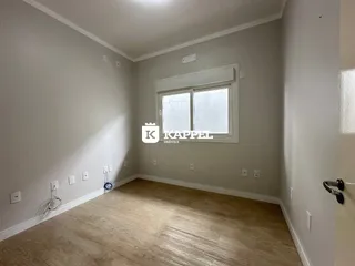 Foto de um cômodo interno com paredes claras e piso de madeira.