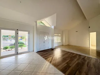 Sala ampla com piso de madeira e cerâmica em uma residência.