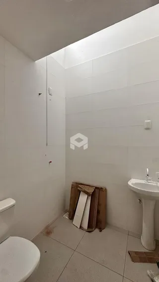 Foto de um banheiro com piso de cerâmica e paredes brancas.
