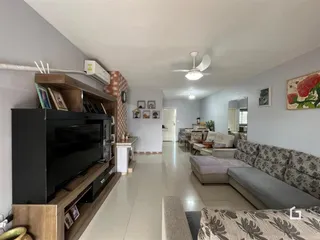Sala de estar com piso de cerâmica e móveis de madeira clara.