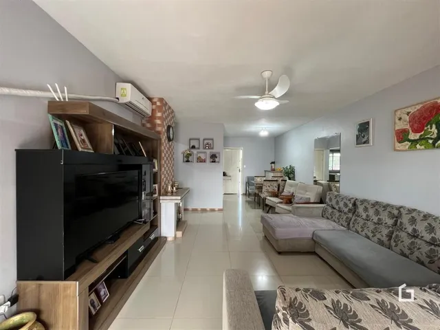 Sala de estar com piso de cerâmica e móveis de madeira clara.