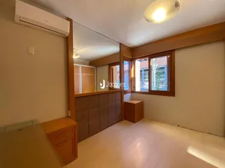 Interior de um cômodo com paredes claras e piso de madeira.