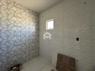 Parede com revestimento geométrico e janela em um ambiente interno.