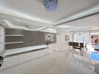 Ambiente interno de sala de estar com piso de porcelanato claro e paredes cinzas.