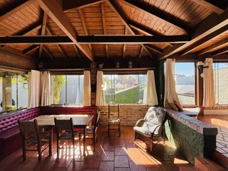 Sala de estar com teto de madeira e vista para o exterior de uma residência.