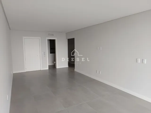 Hall de entrada com piso cinza e paredes brancas.
