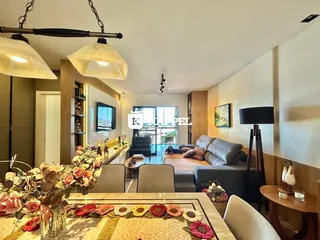 Sala de estar com sofá e mesa de jantar em um apartamento.
