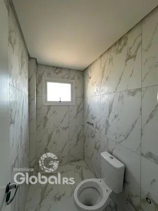 Foto de um banheiro com revestimento em mármore branco.