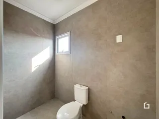 Foto de um banheiro com paredes revestidas de cerâmica e uma janela.