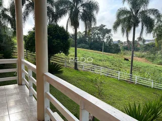 Vista de um campo gramado cercado por uma cerca branca.