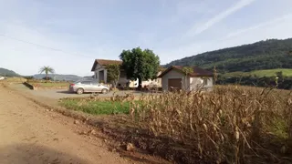 Vista externa de uma propriedade rural em Lajeado, Brasil, com vegetação seca em primeiro plano.