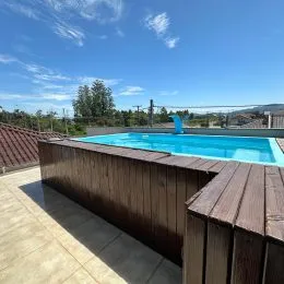 Foto de uma piscina externa com cerca de madeira em uma propriedade.