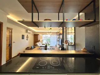 Interior de uma sala de estar moderna com ilha de cozinha e estrutura de mezanino.