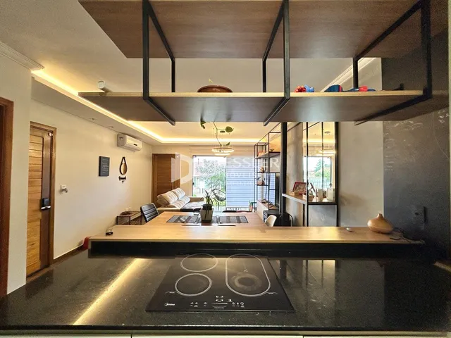 Interior de uma sala de estar moderna com ilha de cozinha e estrutura de mezanino.