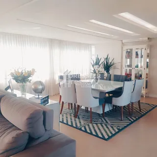 Sala de estar iluminada com grandes janelas e decoração moderna.
