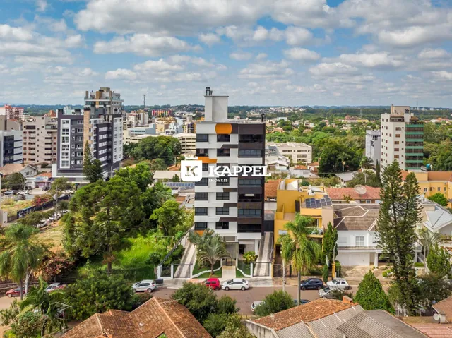 Vista aérea de um bairro residencial em Lajeado, Brasil, mostrando edifícios e vegetação.