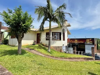 Fachada de uma residência com jardim e árvores em Lajeado.