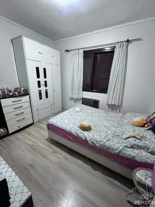 Quarto com cama e armário branco em um apartamento.