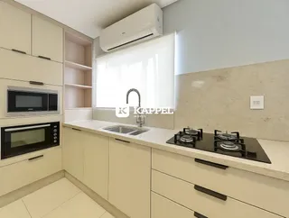 Cozinha moderna com armários claros e bancada.