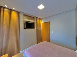 Quarto com paredes claras e painéis de madeira na decoração.