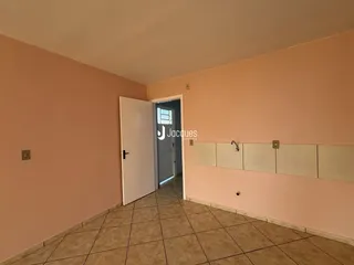 Corredor com piso de cerâmica e armários embutidos na parede.