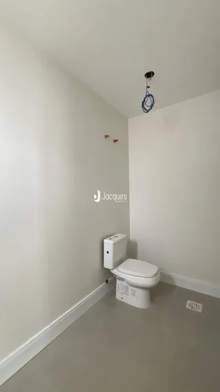 Hall de entrada com vaso sanitário em ambiente claro.