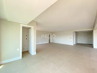 Ambiente interno amplo com piso claro e paredes brancas.