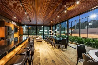 Sala de jantar com piso de madeira e grandes janelas.